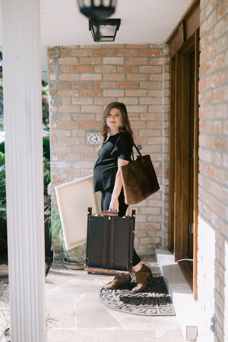 Live Wedding Painter, Stephanie Gaffney leaving her home on the way to paint a wedding, holding canvas and bag of paints
