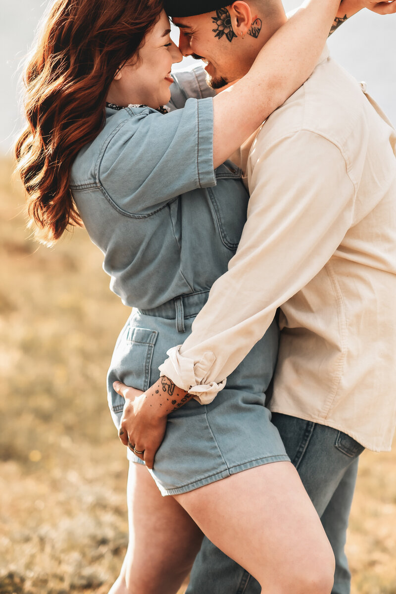 A cute couple hold each other close near Mary's Lake in Estes Park Coloardo