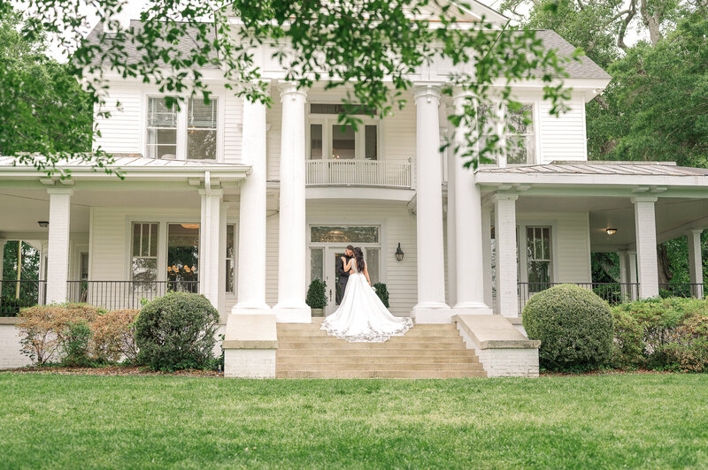 A bride and groom on the porch of their Charlotte wedding venue enjoying their destination wedding photos