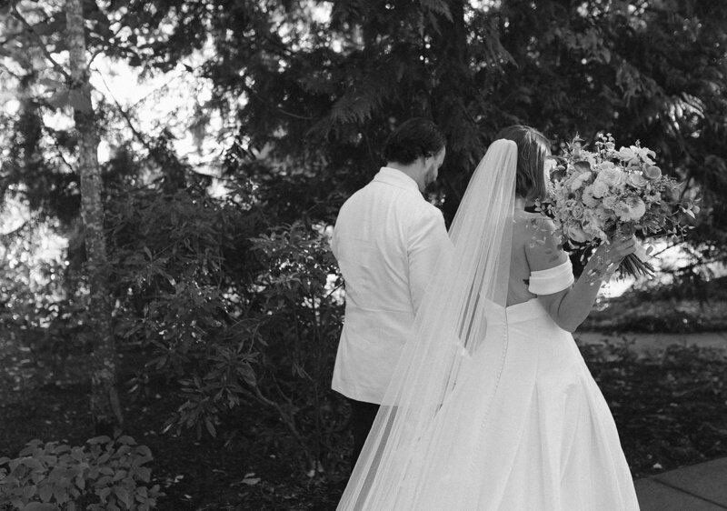 bride looking at groom in front of a column