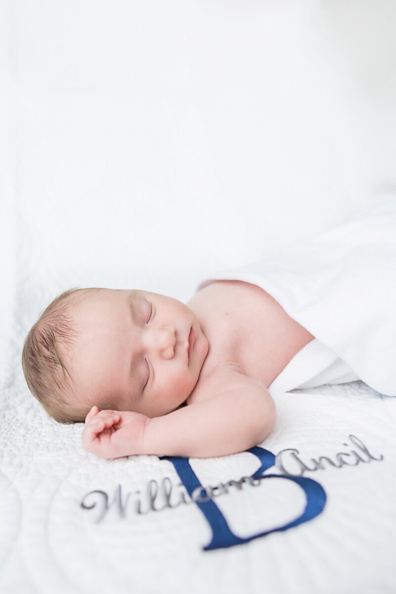 newborn photography savannah, GA of sleeping newborn on monogram blanket