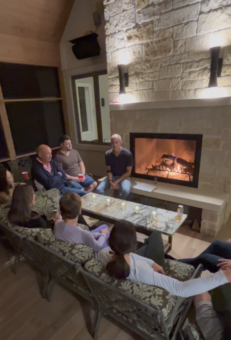 Group of people gathered around a stone fireplace