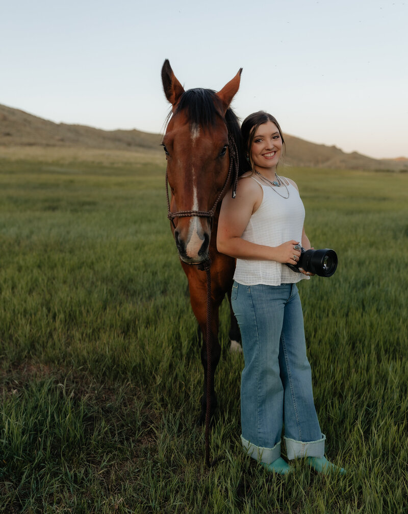 Studio portrait of a Wyoming-based wedding and lifestyle photographer, captured in a clean and professional setup with soft lighting and a relaxed pose.