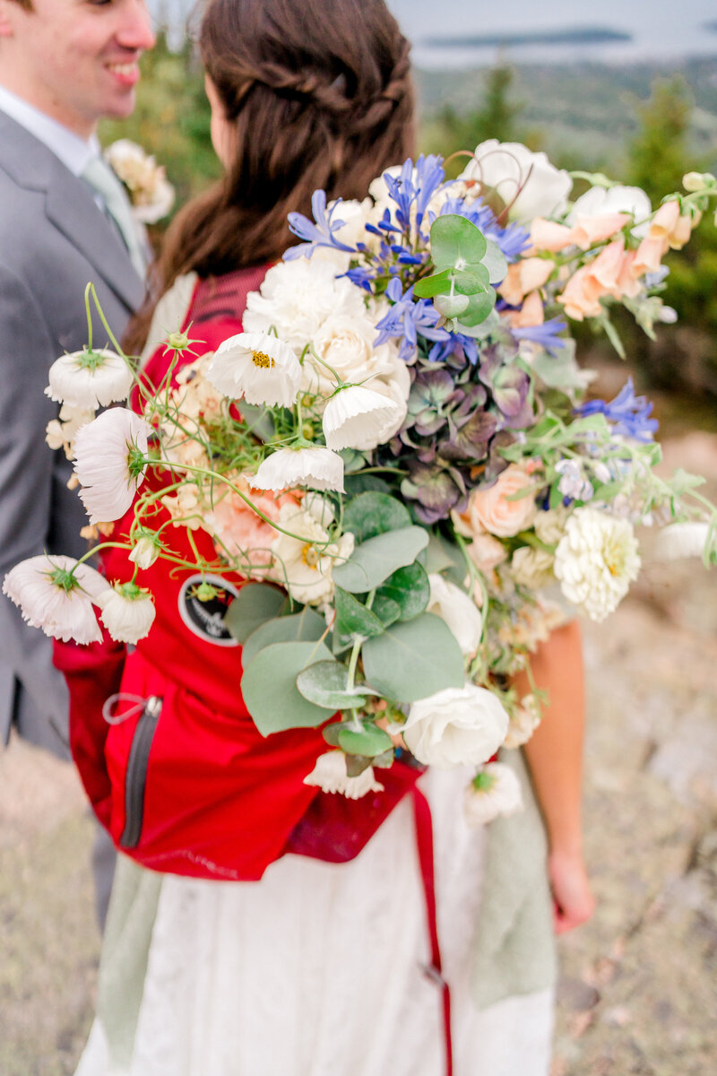Large and beautiful bouquet of flowers in a red backpack | Maine elopement photographer | Adventure and Vows