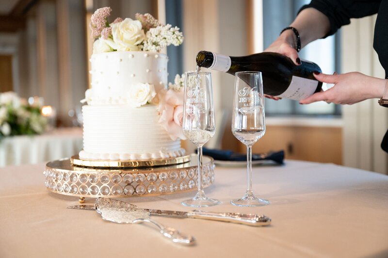 Pouring champagne near wedding cake