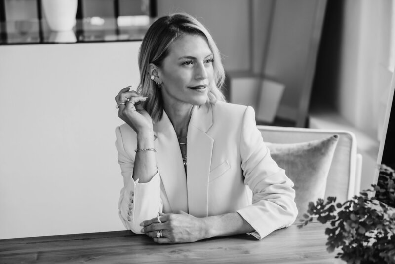 Julie Martin looking off into the distance in a black-and-white portrait, showcasing her elevated and classy style.