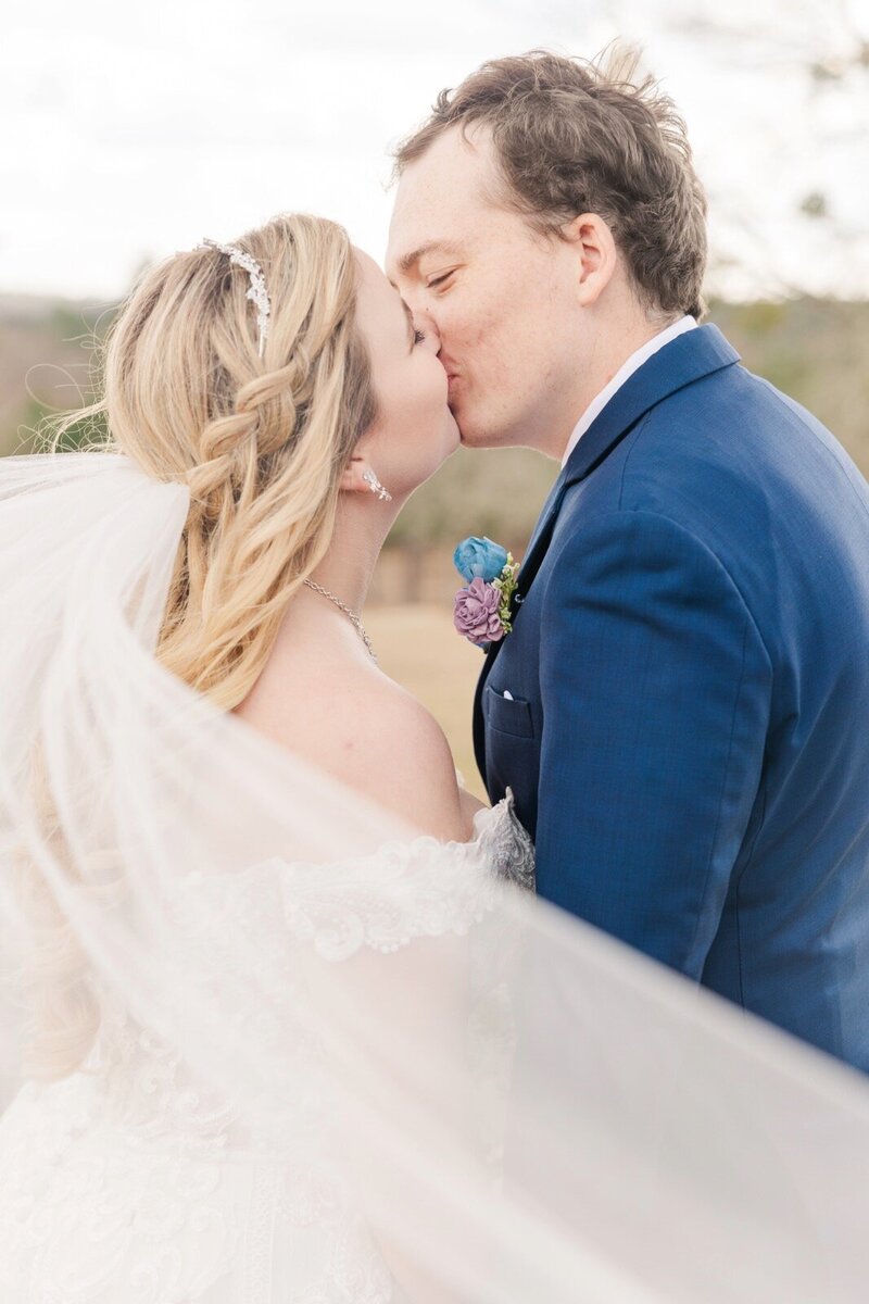 Newlyweds kissing behind a veil