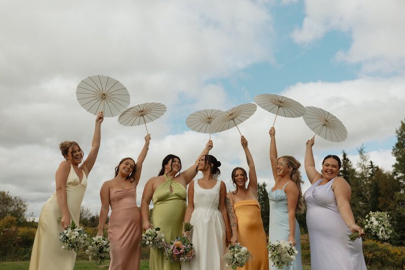 bridal party holding parasols on wedding day in pei