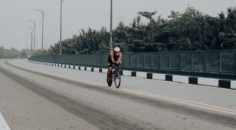 Triathlete cycling down an empty road