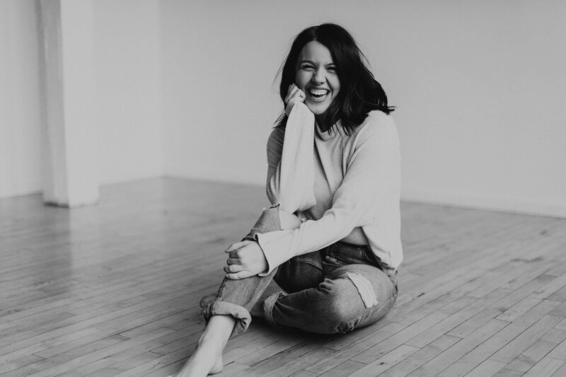 Whitley Sander sitting on the ground smiling at the camera