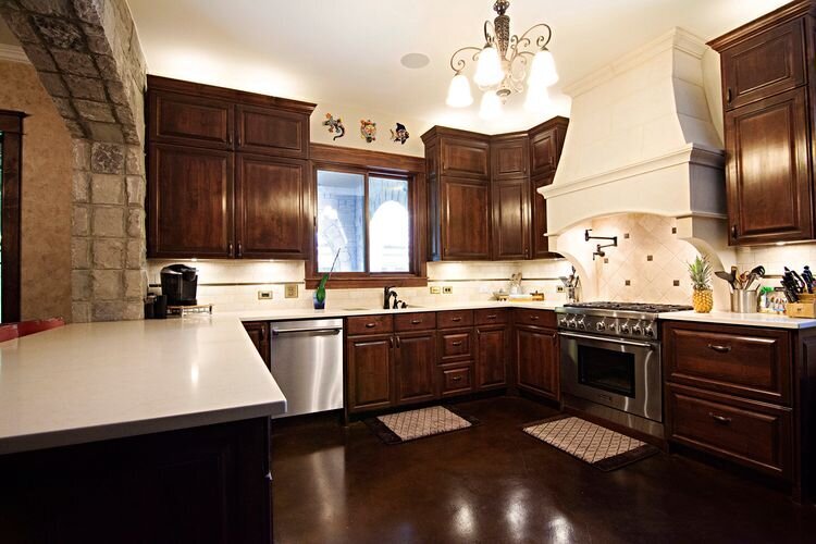 unique kitchen design with mahogany cabinets and white countertops.