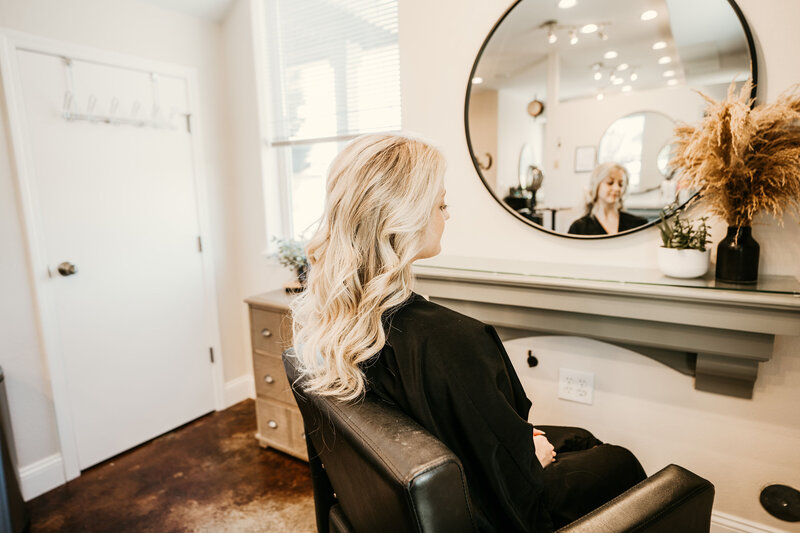 Client seated post-service with styled blonde curls, reflecting the refined and welcoming atmosphere at top-rated Maven + Grace Salon