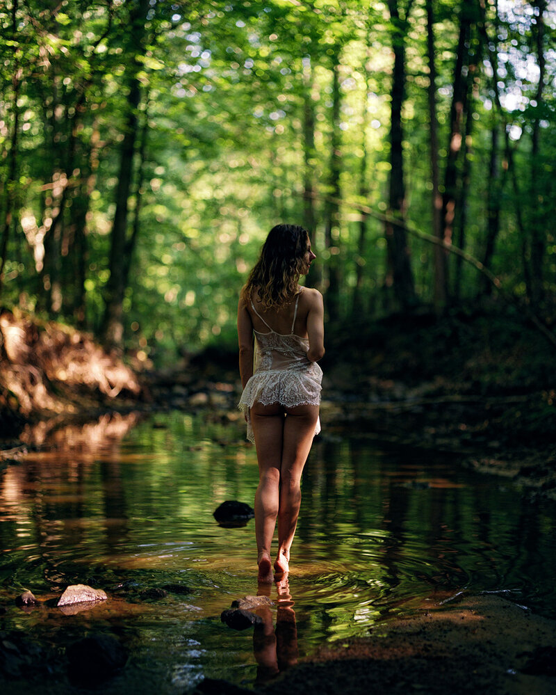woman lying on a duvet cover with tattoos on her body
