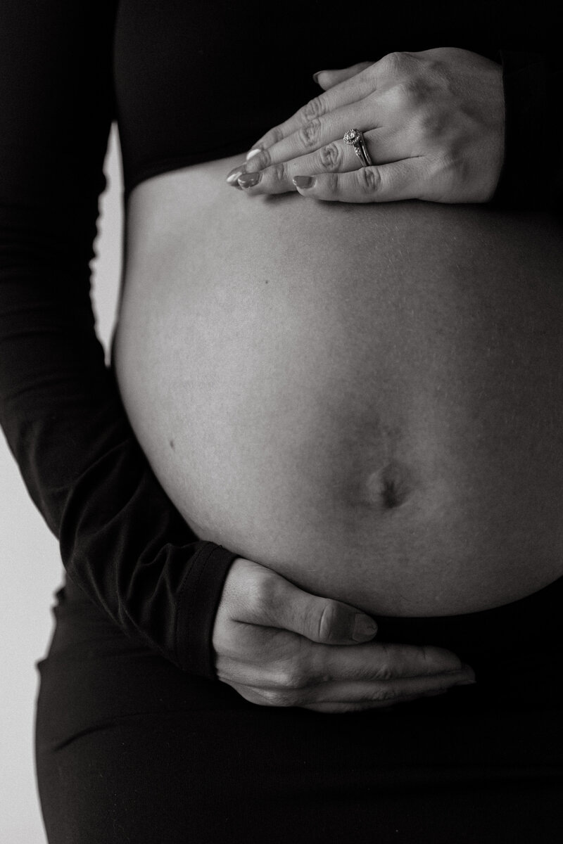 Editorial maternity portraits with fine-art posing and studio session.