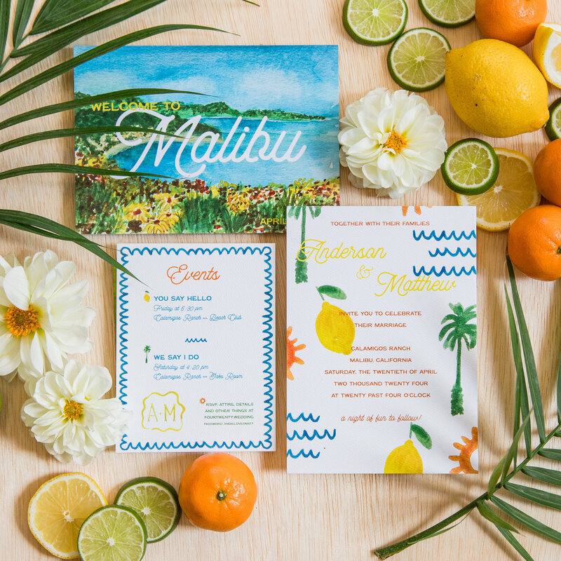 Colorful custom watercolor Malibu California invitation suite with painted lemons, palm trees, suns, and waves surrounded by oranges, limes, and flowers