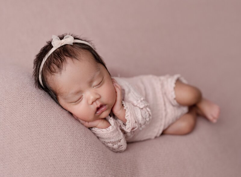 baby girl sleeping in a pink  sleeper