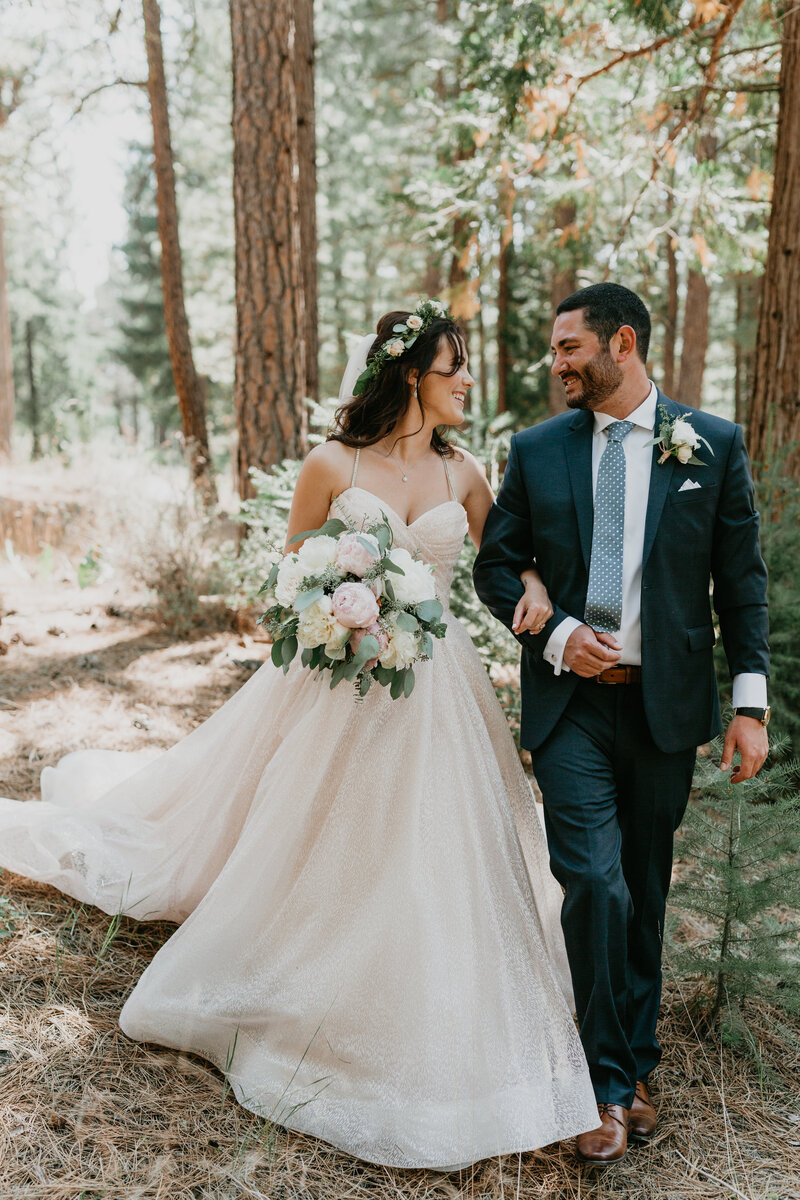 bride and groom walking in the woods