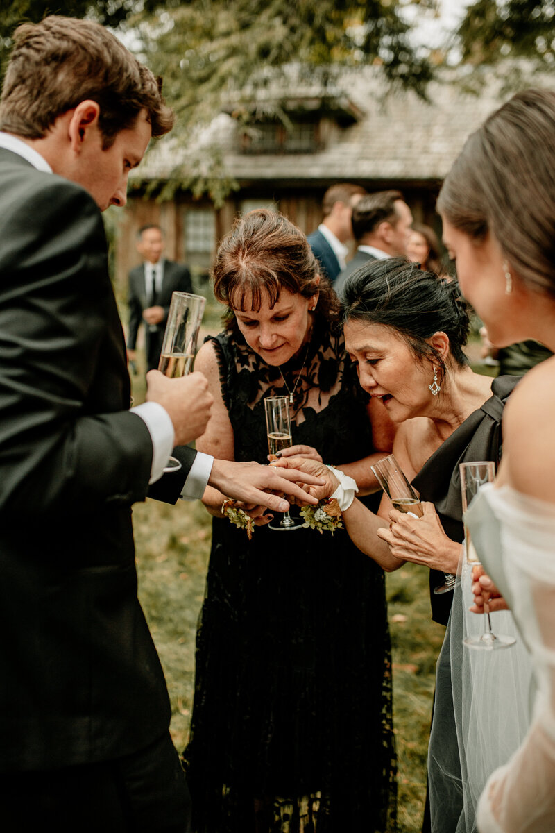 Groom shows off his ring to guests during cocktail hour photographed by Emmie Verdell.
