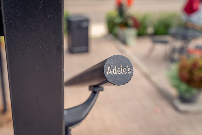 Aluminum ADA deck railing with a custom 3D printed rail caps that say "Adele's". 