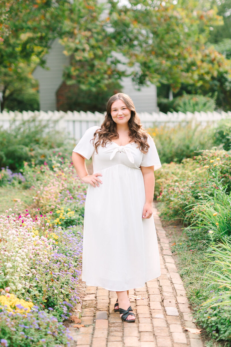 a high school senior standing in the middle of a flower garden