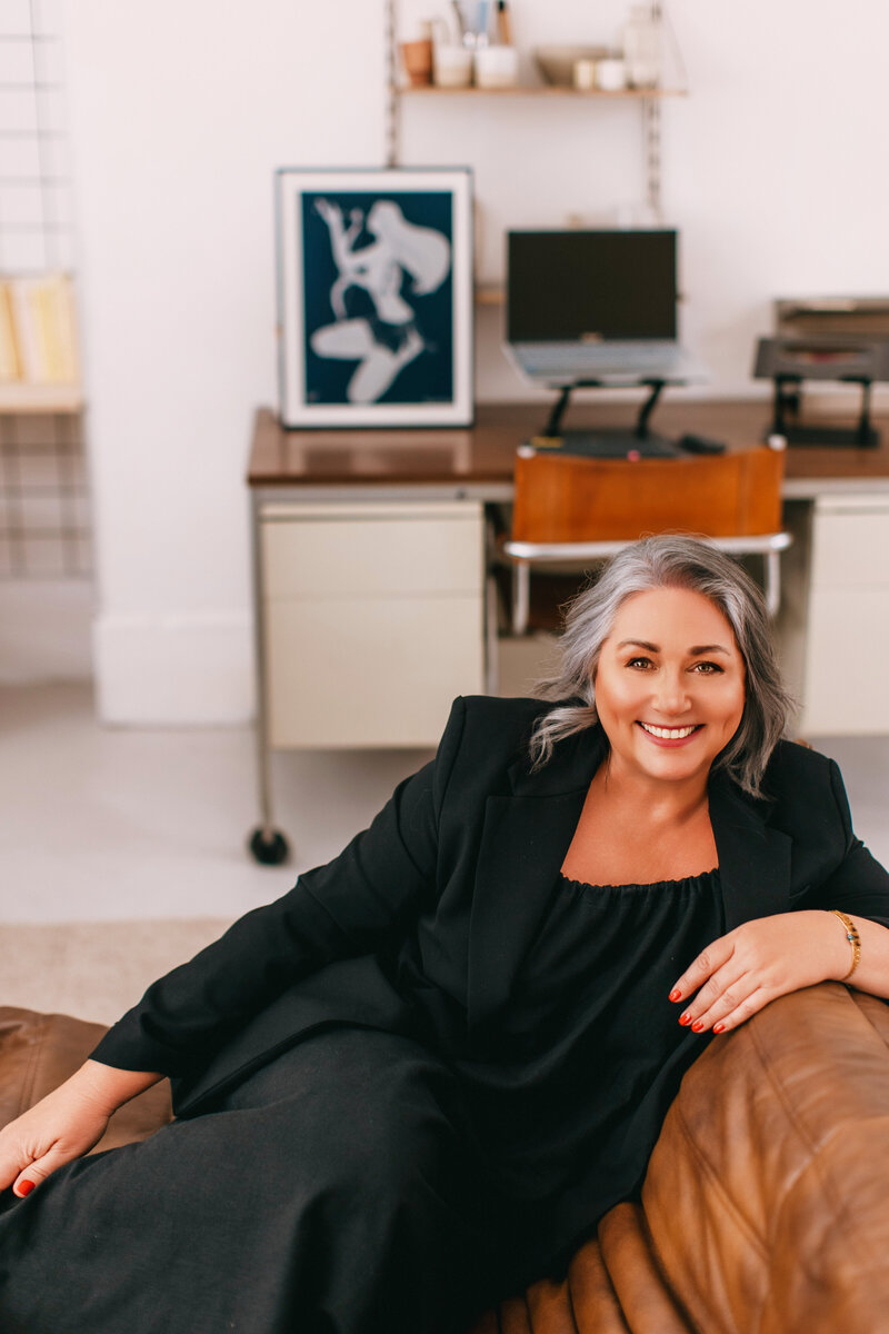 Astrocartographer Kristine Odegard sitting on a leather couch in her office