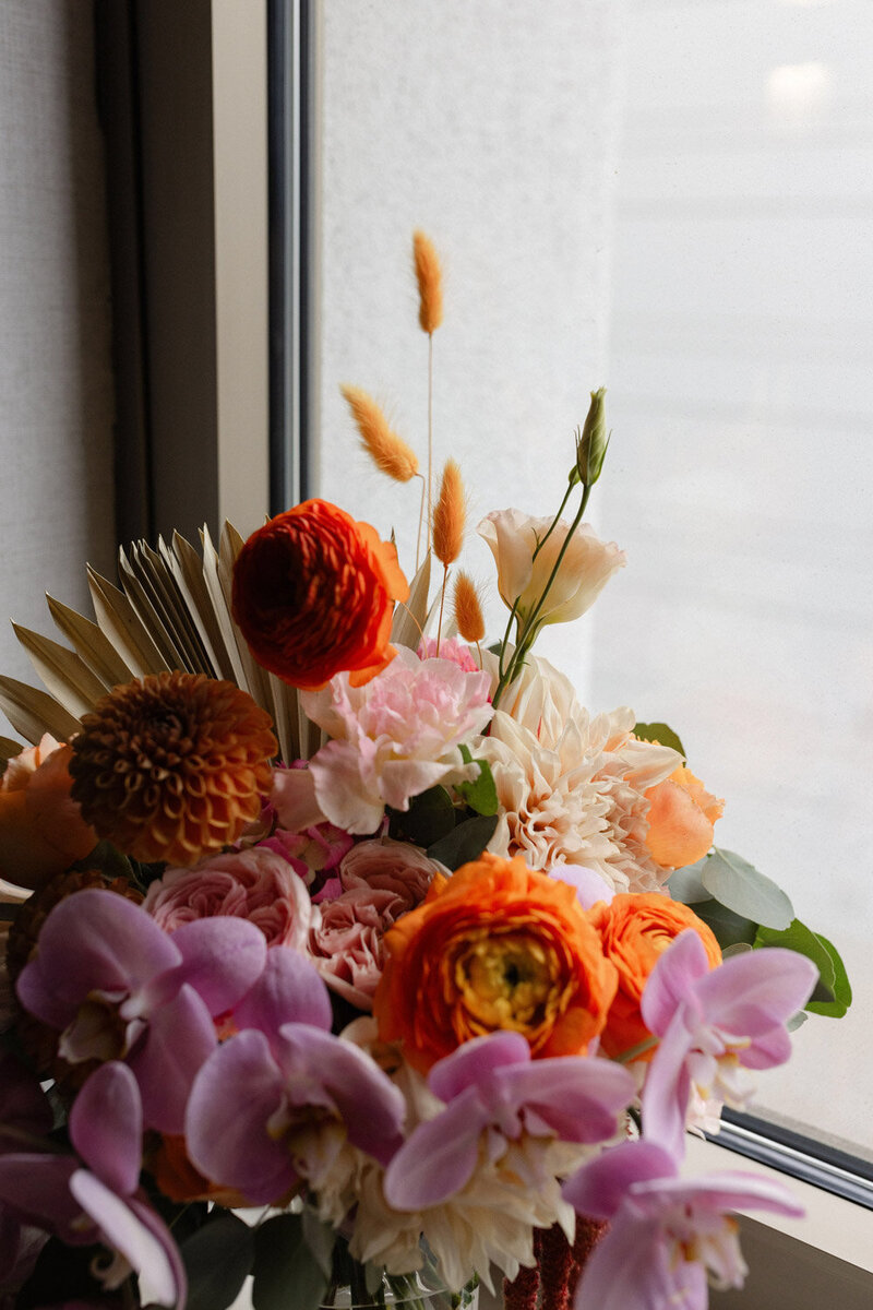 bold colorful floral arrangement with orange, red, and purple tones