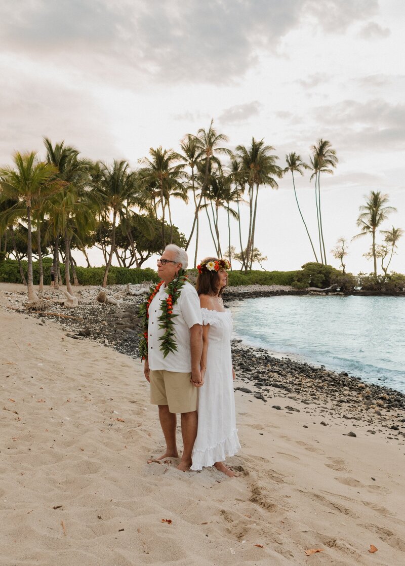 bride and groom standing on beach together