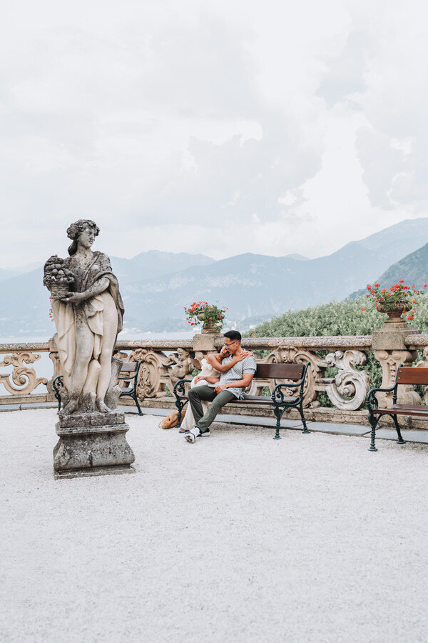 couple hugging on bench in lake como