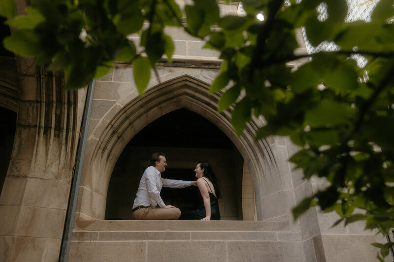 couple kissing in underneath arched buildings