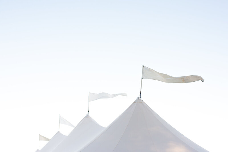 4 white flags on a sailcloth tent blowing in the breeze during a marthas vineyard wedding