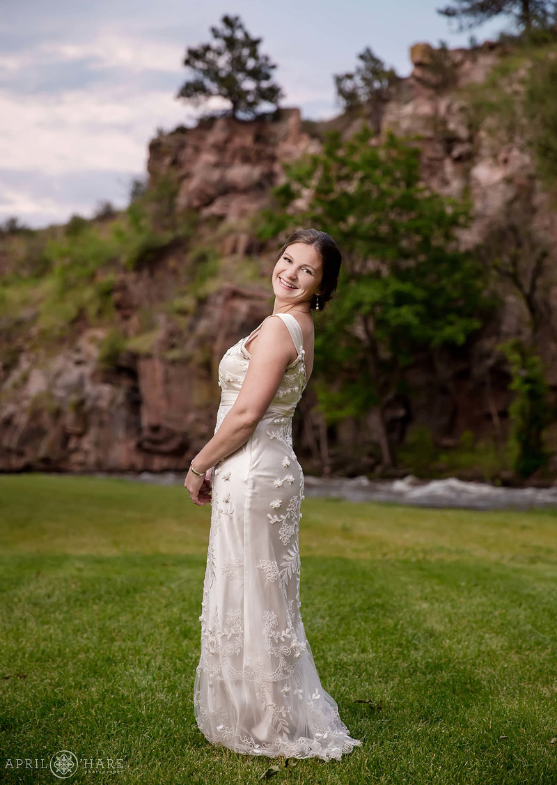 Beautiful bride posing with the pretty red cliffs next to Saint Vrain River at Riverbend wedding venue in Lyons Colorado