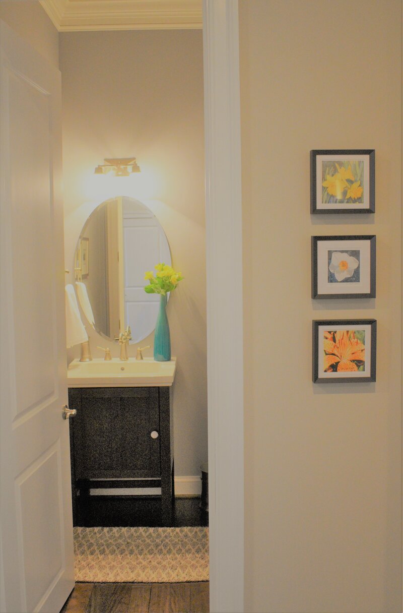 Vase of flowers and art near bathroom