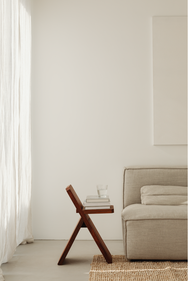 Branded black candlesitting on an an open book on beige timber desk | brandbydesign