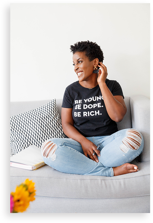 Woman on a couch with legs crossed with her hand behind her head