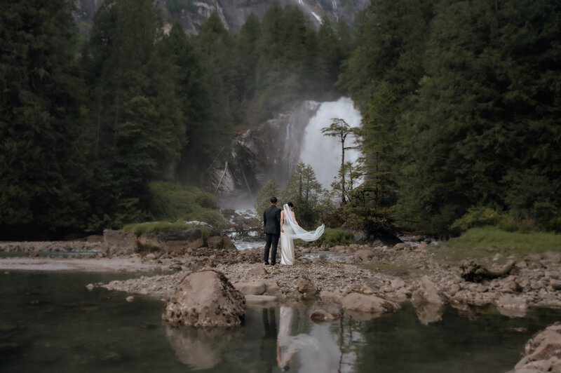Elopement wedding with waterfall backdrop and forest scenery