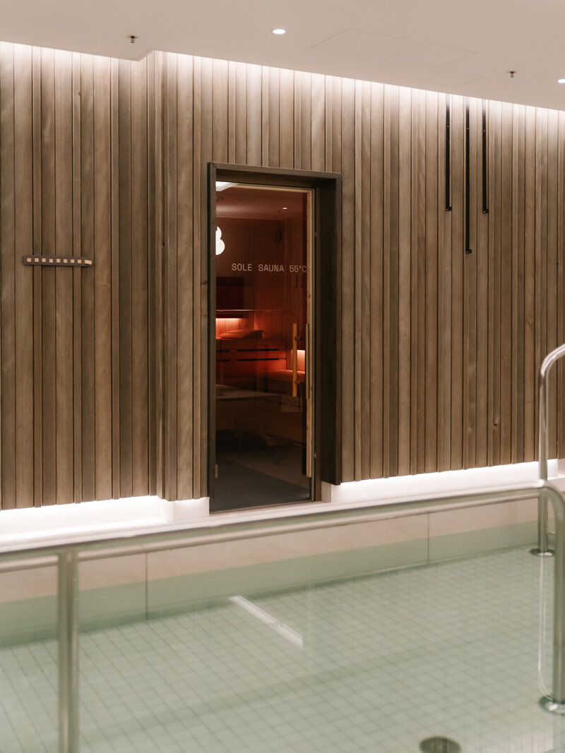 Blick auf die holzverkleidete Sole Sauna und das Wassertretbecken im 639 THE VELA SPA.