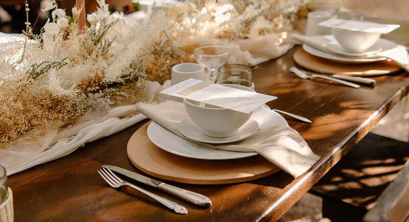 Close-up of neutral and modern table styling at a Tulum elopement, with white ceramics and dried floral centerpieces.