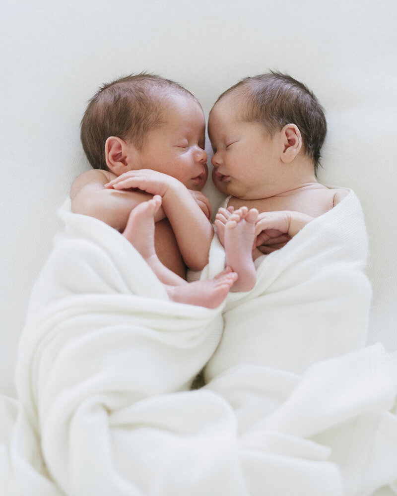 Twins Newborn baby swaddled in neutral wrap, sleeping peacefully on a soft blanket, Perth in home session