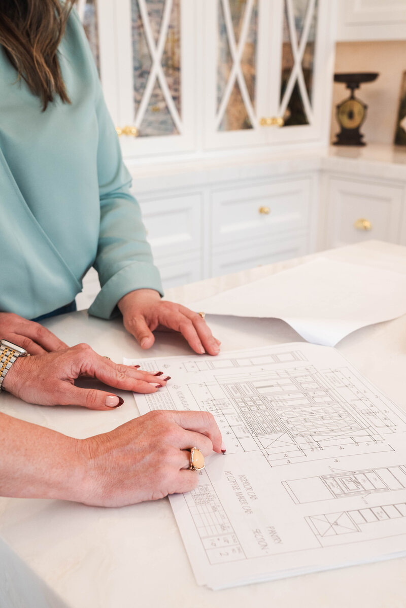 two women at kitchen table looking at ipad with design plans