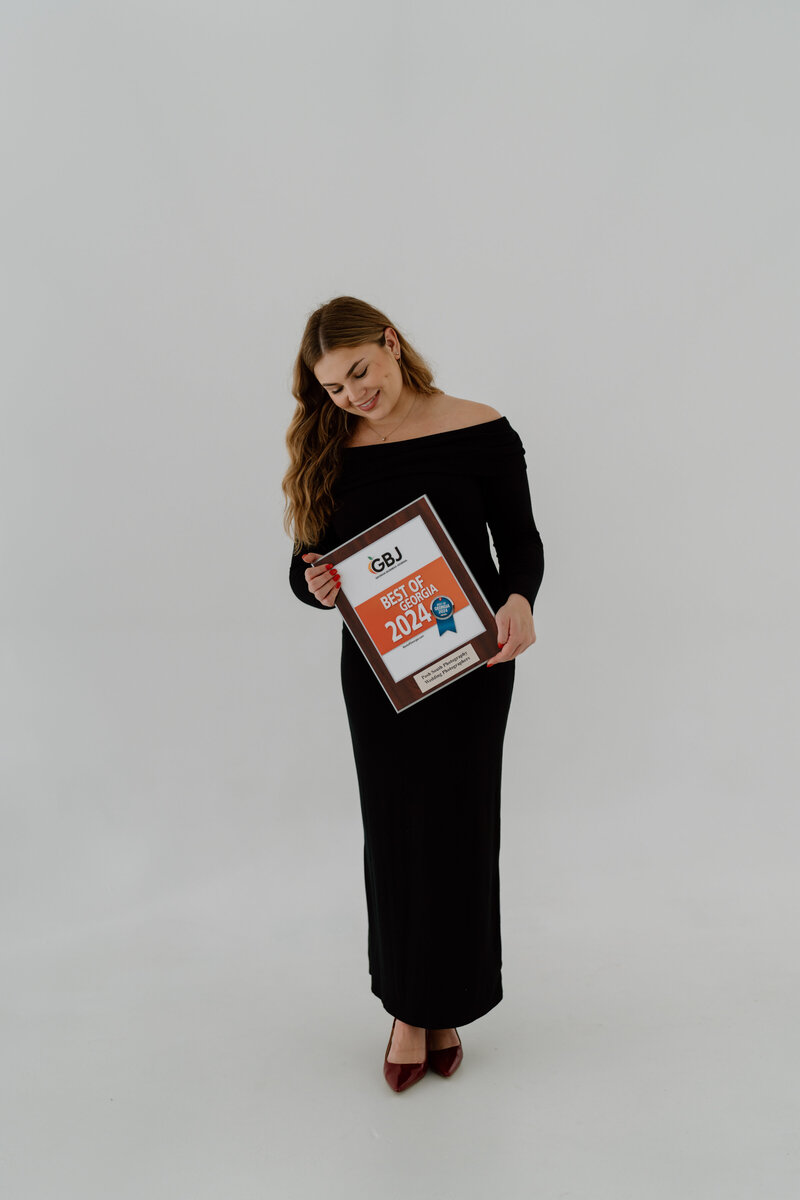 Owner of Posh South Photography, Pairlon Dunagan, holding her Best of Georgia 2024 award