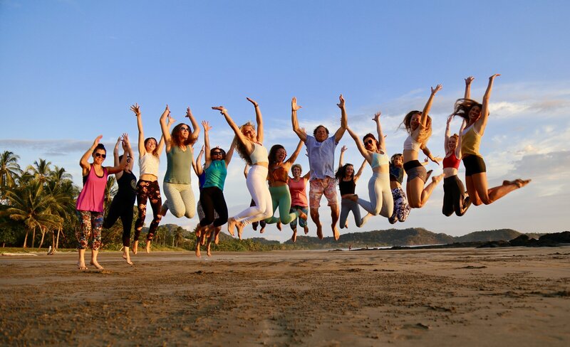 Excited YTT students jump for Joy on the Beach in paradise