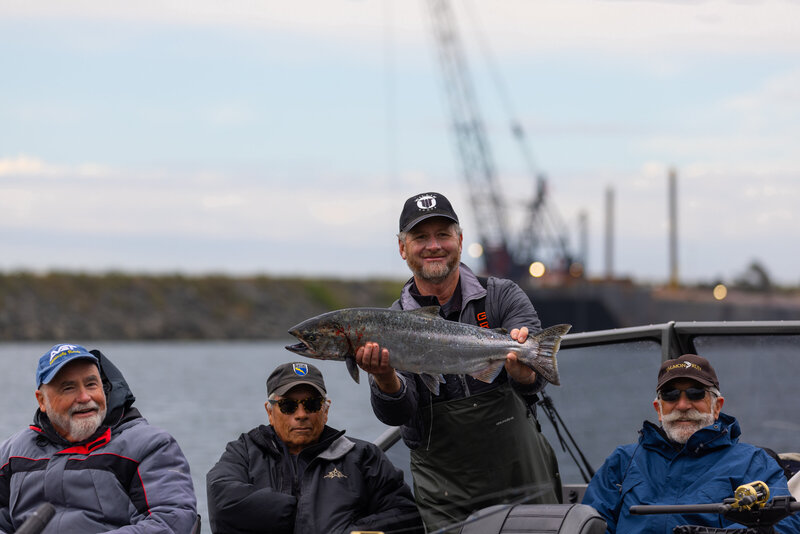 man holding a fish and smiling 