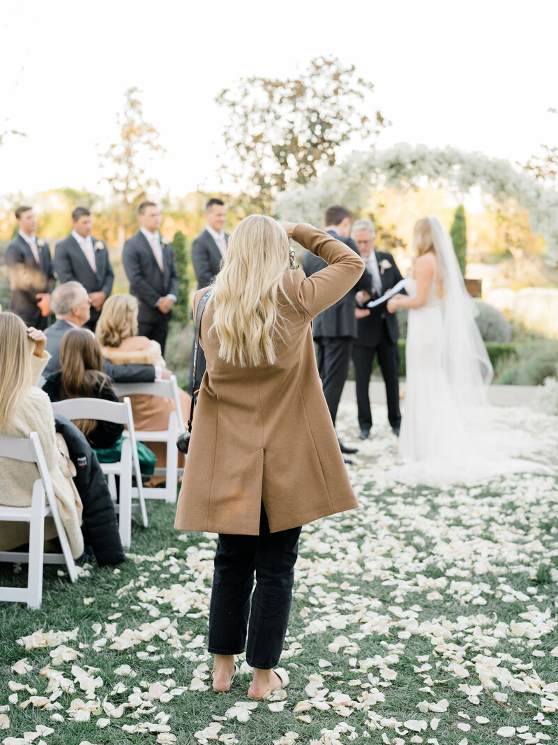 photographer taking pictures of the bride and groom exchanging vows at the ceremony