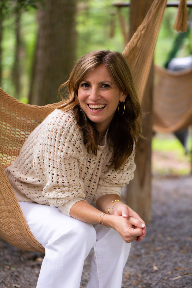 Sam sitting in a hammock in her backyard