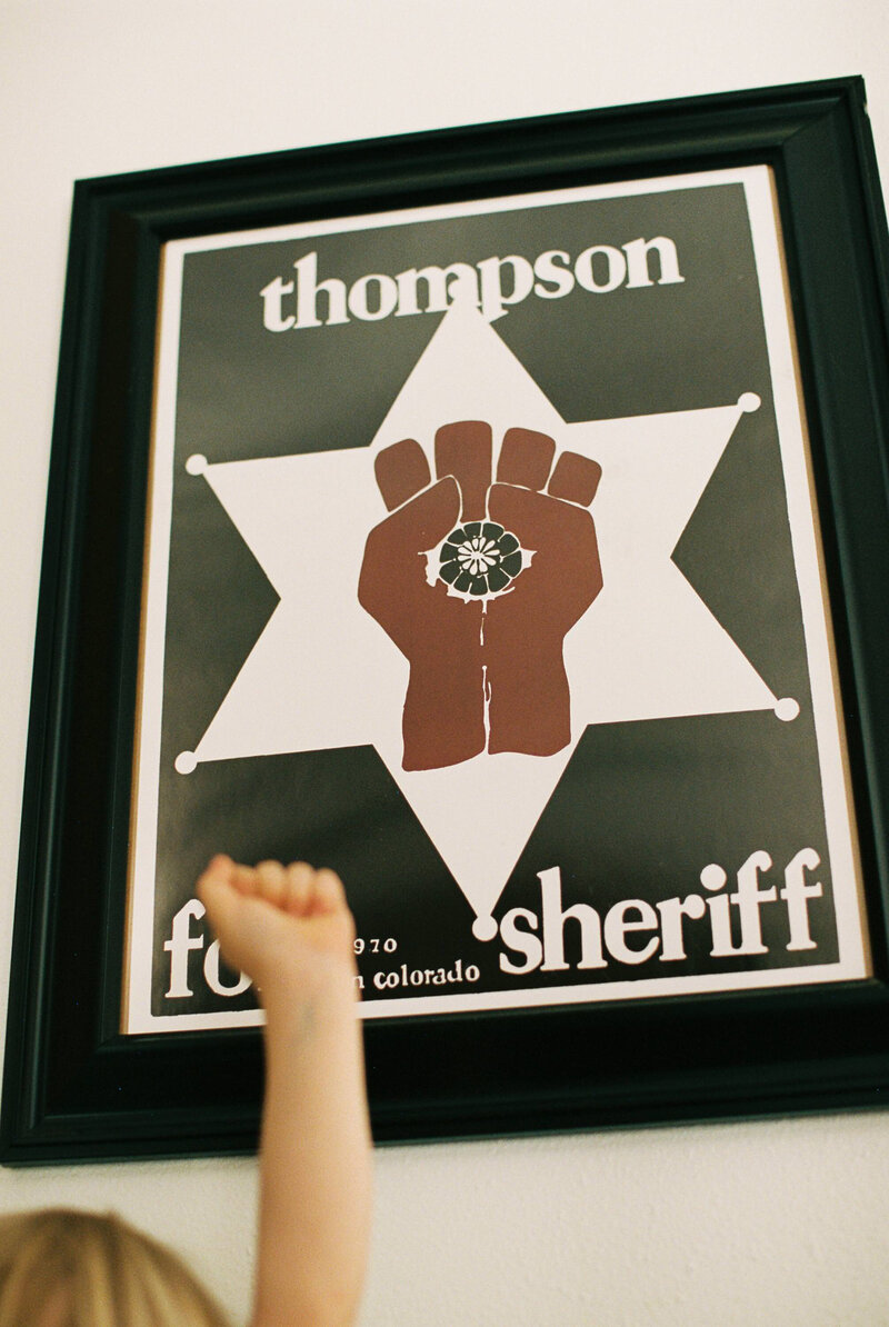a girl holds up her hand  in front of a poster with a hand