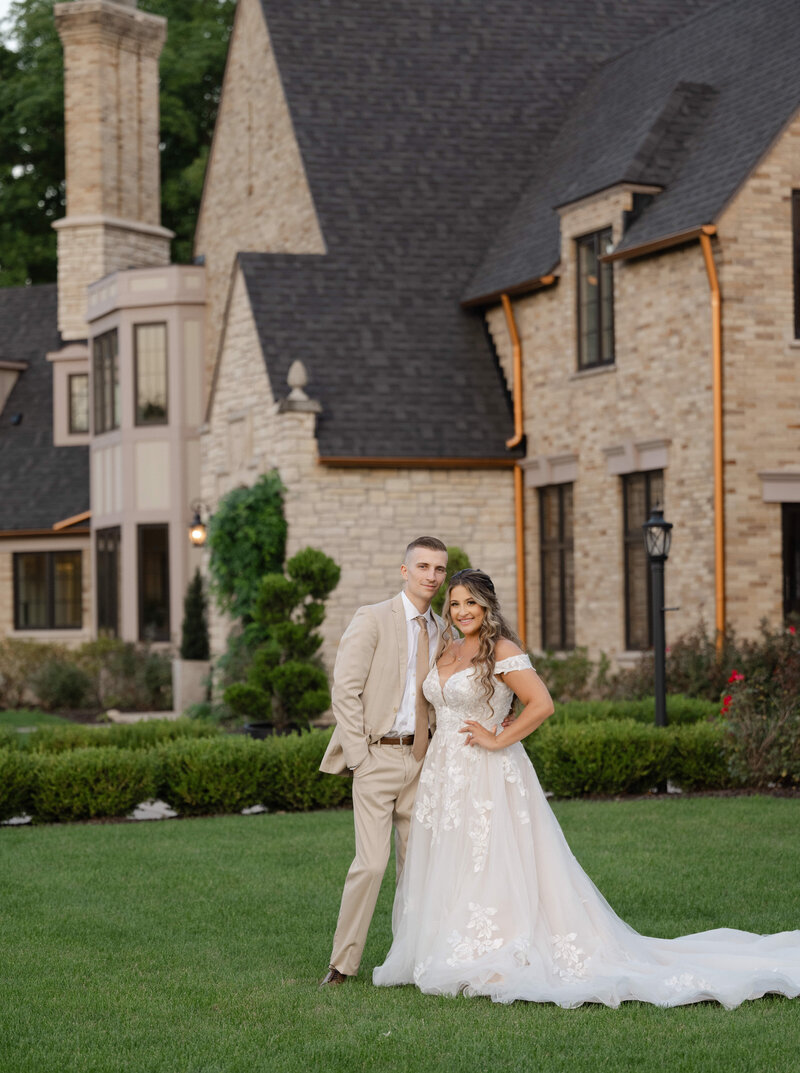 A bride and groom smile for their wedding photo in front of Venue3Two in Grand Rapids