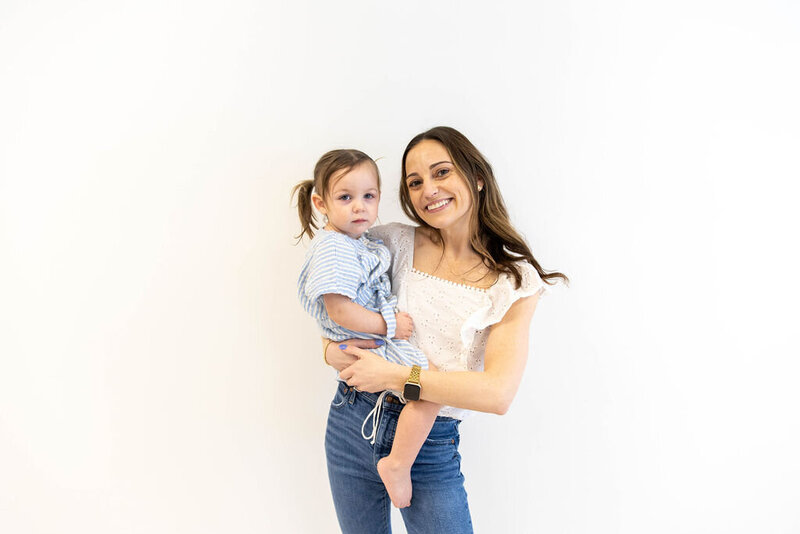 Women smiling as she holds her smiling toddler