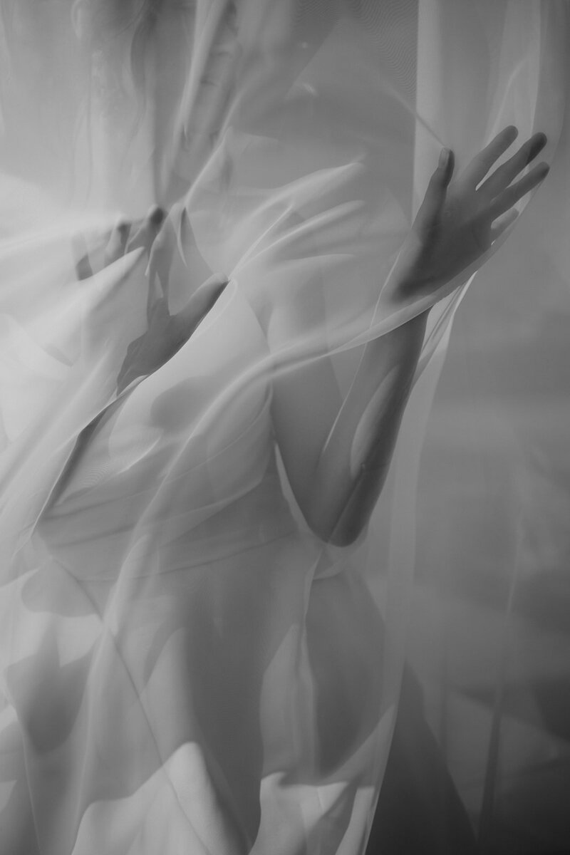A fine art image of a bride behind a sheer curtain at Dover Hall in Virginia