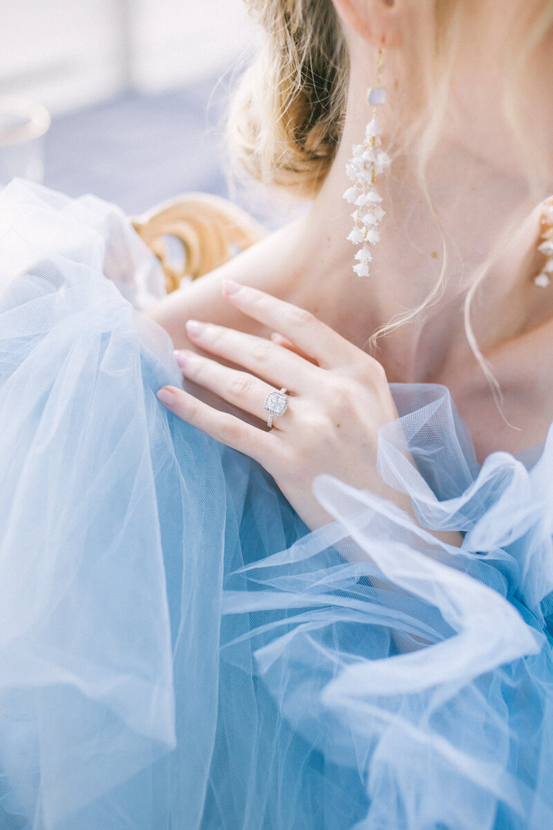close up photo of bride in blue millia london gown showing her ring and ear rings