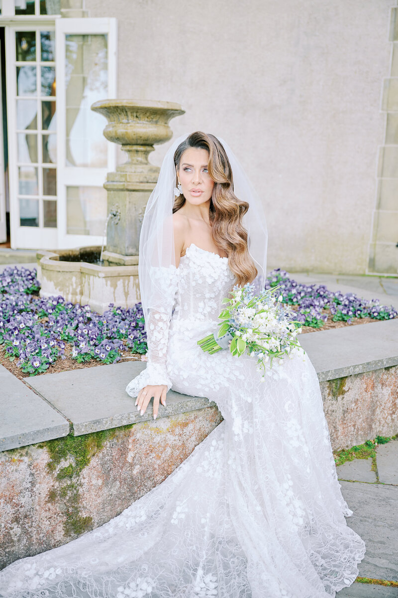 Rhode Island Bride, sits  at the fountain of Glen Manor House. Taken by New York City Photographer Corey Lamar Photography